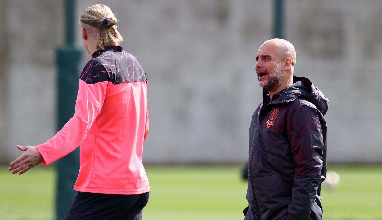 Pemain Manchester United, Erling Haaland bercanda dengan pelatih Pep Guardiola saat melakukan latihan jelang laga perempat final Liga Champions 2023/2024 melawan Real Madrid di Etihad Campus, Manchester, Inggris, 8 April 2024 waktu setempat. (AFP/Darren Staples)