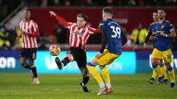 Pemain Brentford Mathias Jensen (tengah) berebut bola dengan pemain Manchester United Scott McTominay pada pertandingan sepak bola Liga Inggris di Brentford Community Stadium, London, 19 Januari 2022. Manchester United menang 3-1. (AP Photo/Matt Dunham)