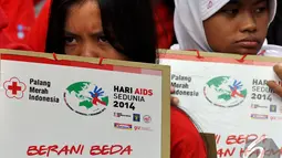 Dua orang remaja membawa poster saat mengikuti "Celebrate Dance4life 2014", Bundaran HI, Jakarta, Minggu (7/12/2014). (Liputan6.com/Miftahul Hayat)