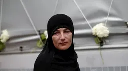 Seorang wanita tampak lesu saat berdiri di depan truk yang membawa 136 peti mati korban pembantaian Srebrenica, di desa Visoko, Bosnia-Herzegovina, Kamis, (9/7/2015). Rencananya, jenazah akan dimakamkan pada 11 Juli mendatang. (REUTERS / Stoyan Nenov)