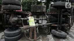 Petugas melakukan evakuasi Kontainer yang terguling di Jalan S Parman, Jakarta Barat, Senin (4/5/2020). Tidak ada korban jiwa dalam kecelakaan tersebut, namun kecelakaan tersebut membuat lalin dijalan itu terimbas kemacetan yang cukup panjang. (Liputan6.com/Johan Tallo)