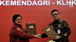 Mendagri Tjahjo Kumolo (kanan) bersama Menteri LHK Siti Nurbaya menunjukkan dokumen Nota Kesepahaman di Jakarta, Selasa (19/2). Pemanfaatan data kependudukan Kemendagri ini untuk dipergunakan dalam beberapa hal tertentu. (Merdeka.com/Iqbal Nugroho)