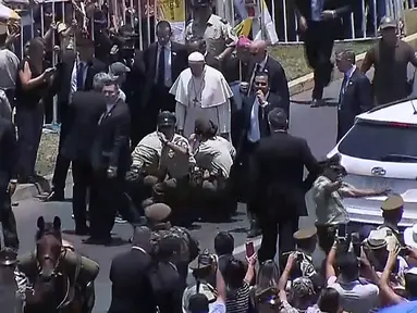 Paus Fransiskus menghampiri polisi perempuan yang terjatuh dari kudanya saat rombongan Pemimpin Gereja Katolik Roma itu melewati umat di jalanan kota Iquique, Chile, Kamis (18/1). (HO/NATIONAL COMMISSION FOR THE POPE’S VISIT AND CHILEAN CHANNELS/AFP)