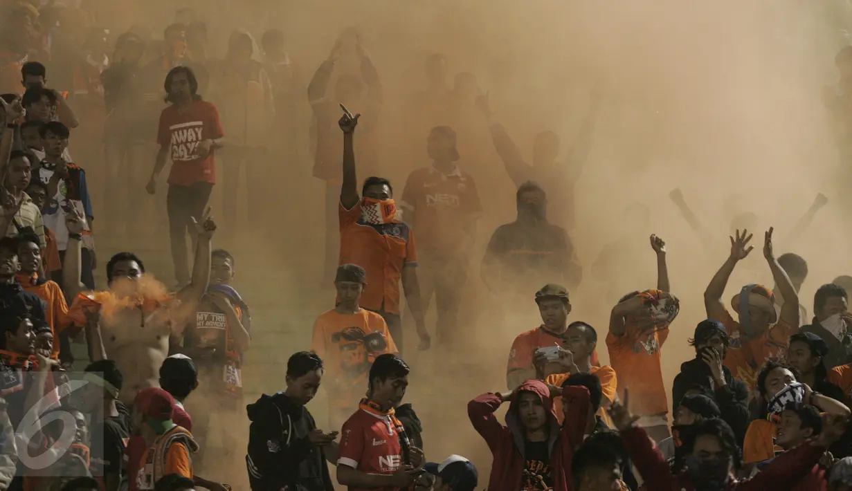 Suporter Persija membakar kembang api pada pertandingan 8 besar Piala Jendral Sudirman antara Persija vs Semen Padang di Stadion Manahan Solo, Minggu (20/12). Skor akhir 6-5 untuk Persija, namun tetap tak lolos ke babak semifinal. (Boy Harjanto)