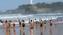 Orang-orang berjalan di pantai Port Vieux, (Old Seaport) di Biarritz, barat daya Prancis, (19/4). Suhu di Prancis barat daya telah mencapai 27 derajat Celcius (80,6 Fahrenheit). (AP Photo / Bob Edme)