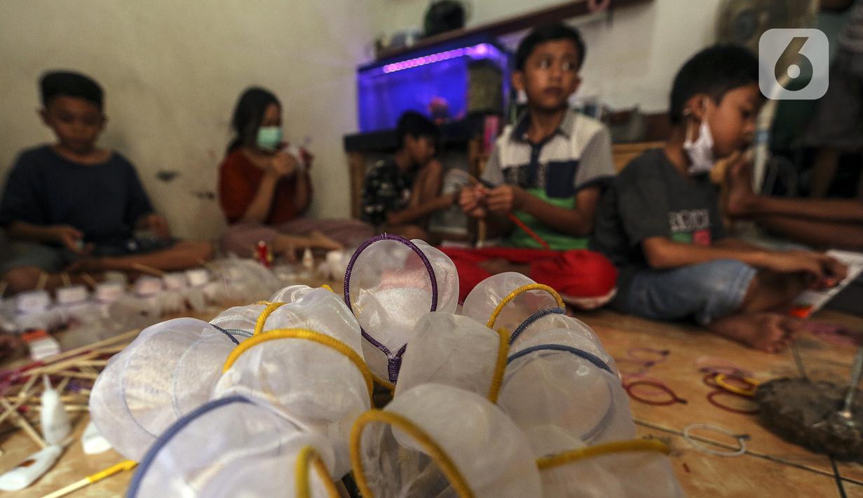 Anak-anak membuat serokan ikan cupang di rumah kontrakan Udin, Sukabumi Selatan, Jakarta Barat, Selasa (22/12/2020). Anak-anak membantu membuat serokan ikan cupang setelah tugas sekolah selesai. (Liputan6.com/Johan Tallo)