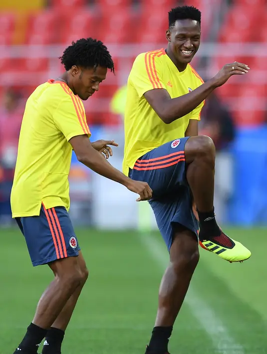 Gelandang Kolombia Yerry dan  Juan Cuadrado bercanda saat mengikuti latihan di Stadion Spartak di Moskow, Rusia(2/7). Kolombia akan bertanding melawan Inggris pada babak 16 besar Piala Dunia 2018. (AFP Photo/Francisco Leong)