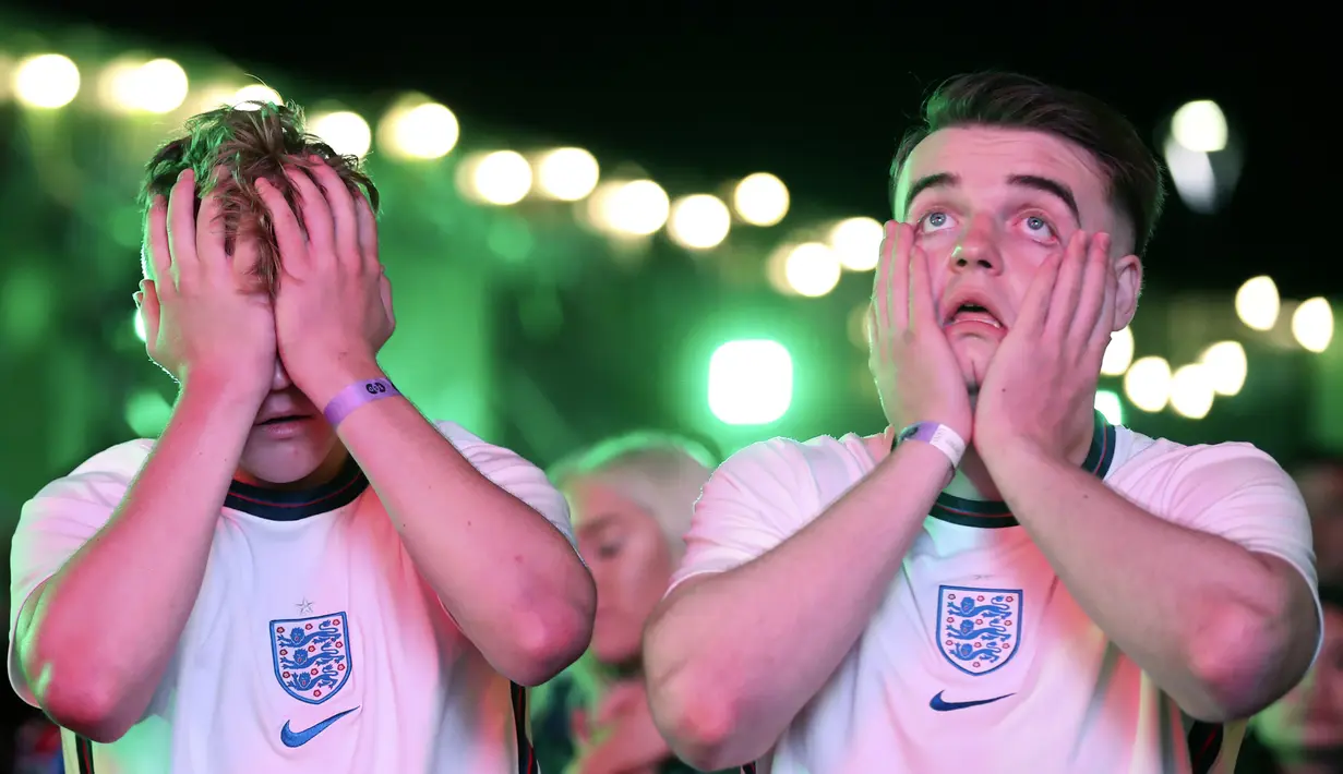 Suporter Inggris bereaksi setelah Italia memenangkan pertandingan final Euro 2020 di zona penggemar di Newcastle, Inggris, Minggu (11/7/2021). Italia menang 3-2 lewat adu penalti dengan Inggris usai bermain imbang 1-1 di waktu normal. (AP Photo/Scott Heppell)