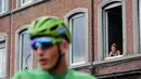 Seorang wanita menonton dari jendela saat pebalap Jerman, Marcel Kittel meraih jersey hijau pada etape ketiga Tour de France dari Verviers, Belgia dan finish di Longwy, Prancis, (3/7/2017). (AP/Christophe Ena)