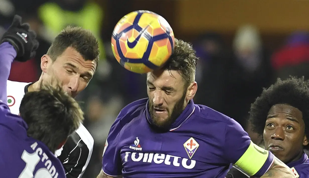 Bek Fiorentina, Gonzalo Rodriguez, duel udara dengan pemain Juventus. Meski kalah, Juventus lebih menguasai jalannya laga dengan penguasaan bola 53 persen, namun Fiorentina lebih banyak memiliki kesempatan mencetak gol. (AFP/Andreas Solaro)
