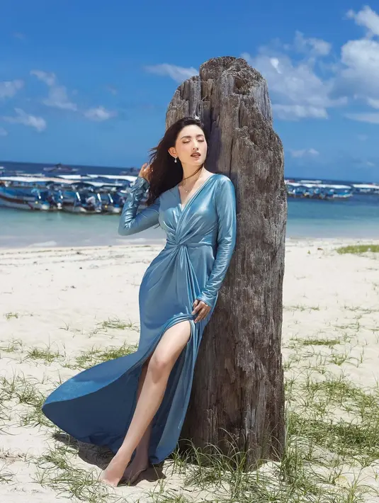 Mengenakan maxi dress dengan high slit (Instagram @natashawilona12)