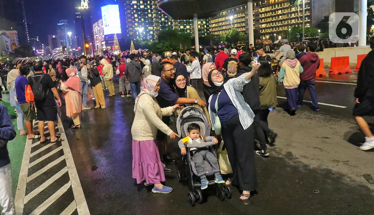 Warga memadati Car Free Night (CFN) pada malam pergantian tahun baru 2023 di kawasan Bundaran Hotel Indonesia, Jakarta, Sabtu (31/12/2022). Pemprov DKI Jakarta juga menerapkan car free night (CFN) di sepanjang kawasan Sudirman-MH Thamrin pada pukul 20.00 hingga pukul 02.00 dini hari. (Liputan6.com/Angga Yuniar)