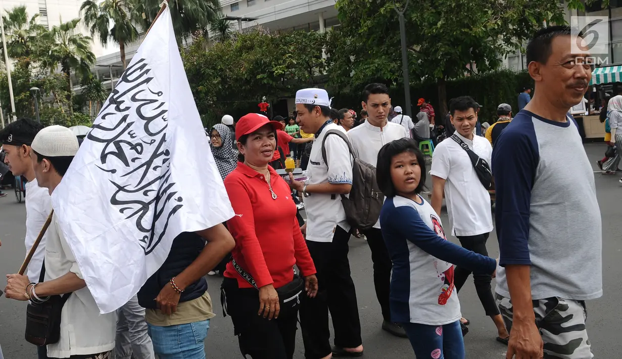 Sejumlah warga beraktivitas di antara peserta Reuni 212 saat Car Free Day (CFD) di kawasan Jakarta, Minggu (2/12). Warga tetap memadati area Car Free Day  dari Bundaran HI-Sudirman meskipun ada aksi Reuni 212. (Liputan6.com/Angga Yuniar)