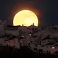 Bulan purnama tampak dari atap sebuah di Olivera, Spanyol Selatan.   Bulan terlihat lebih besar dari biasanya karena pada saat ini bulan   berada pada titik yang terdekat dengan bumi (REUTERS/Jon Nazca)