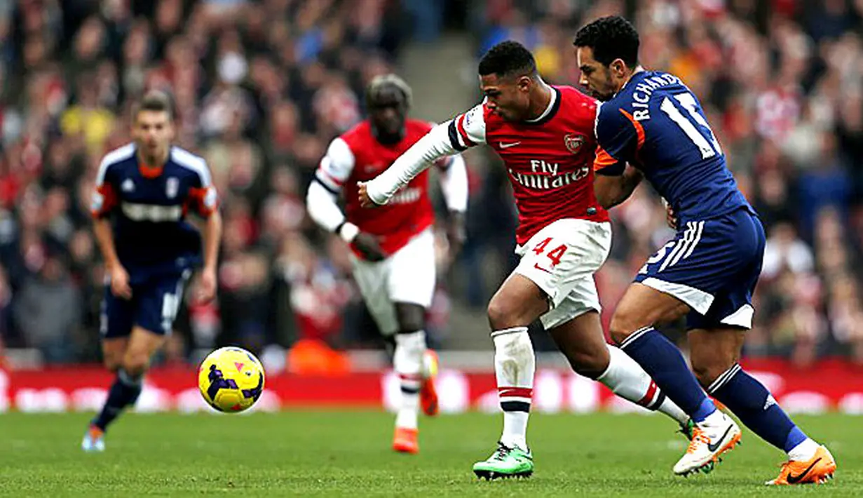 Serge Gnabry Berusaha mempertahankan bola dari Kieran Richardson pada pertandingan sepak bola Liga Inggris antara Arsenal vs Fulham di Stadion Emirates, London (18/01/14). (AFP/Adrian Dennis)
