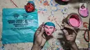 Masudi alias Bang Ntong Salam (40) mewarnai kepala miniatur ondel-ondel di Jalan Gang 3, Kelurahan Pondok Kopi, Kecamatan Duren Sawit, Jakarta Timur, Selasa (19/10/2021). Harga miniatur ondel-ondel Bang Ntong tergantung tingkat kerumitan pembuatan. (merdeka.com/Iqbal S. Nugroho)