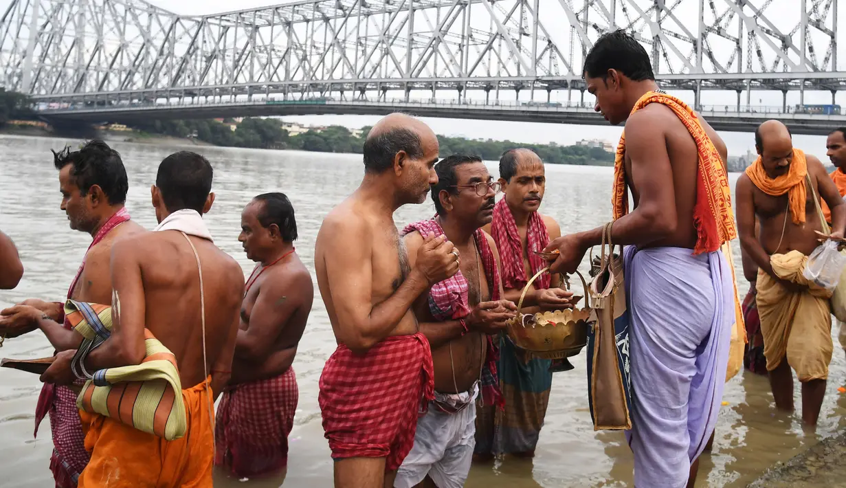 Umat Hindu melakukan ritual 'Tarpan' pada hari Pitrupaksh di Sungai Gangga di Kolkata (19/9). Hari Pitrupaksh menggambarkan hari ketika para dewa menciptakan dewi dewi untuk menghancurkan raja setan Asura. (AFP Photo/Dibyangshu Sarkar)