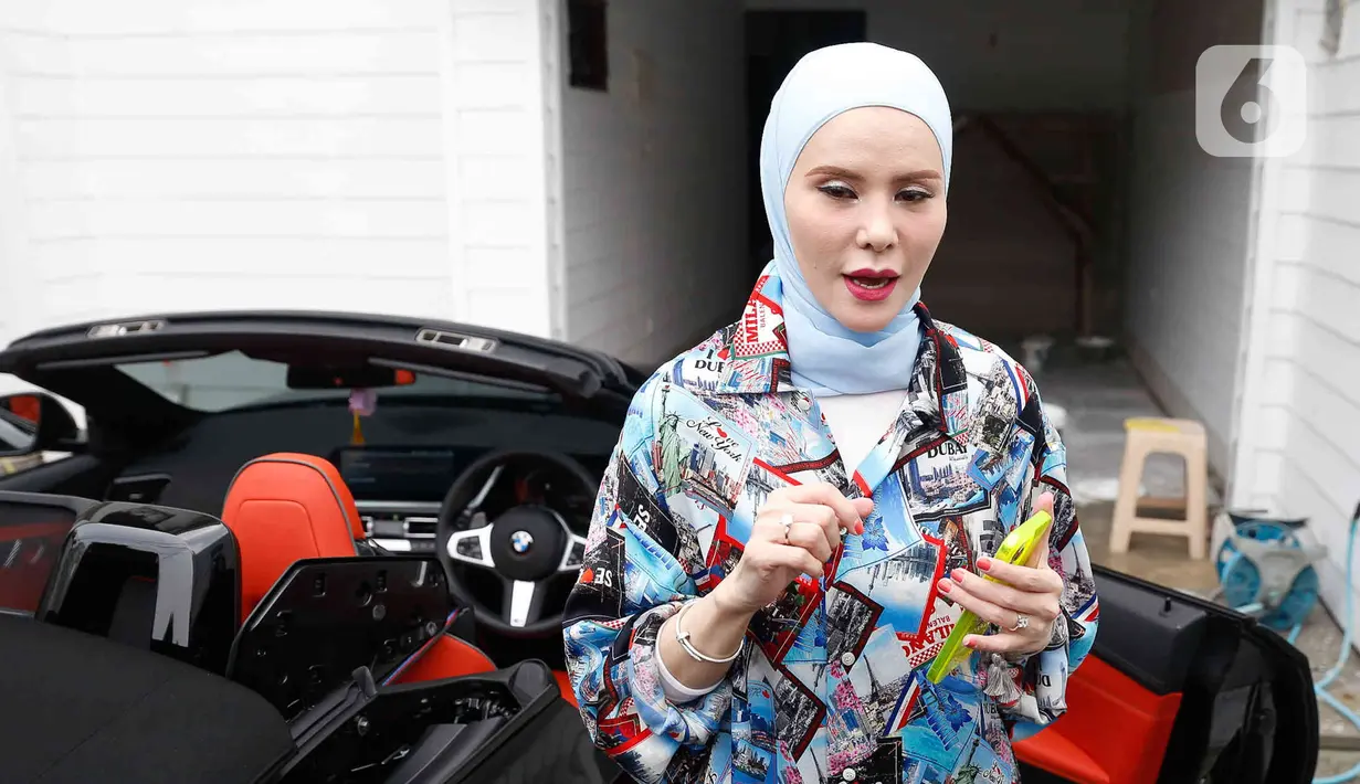 Aktris Angel Lelga turun dari kendaraannya di kediamannya di kawasan Jagakarsa, Jakarta, Rabu (6/7/2022). Meski baru mengenakan hijab sejak beberapa tahun lalu, gaya hijab Angel Lelga tergolong unik karena memilih model hijab era tahun 1980-an yang dimodifikasinya dengan gaya modern. (Liputan6.com/Herman Zakharia)