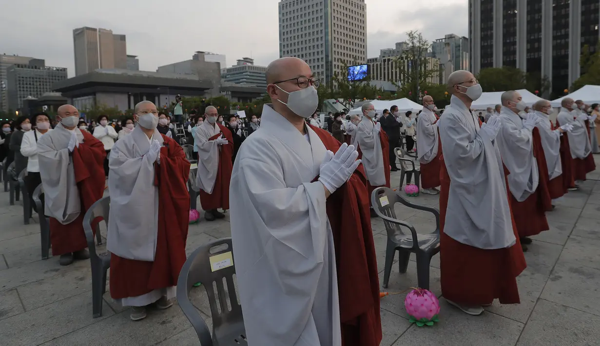 Para biksu mengenakan masker saat merayakan ulang tahun Buddha di Gwanghwamun Plaza, Seoul, Korea Selatan, Kamis (30/4/2020). Ulang tahun Buddha kali ini dirayakan di tengah pandemi virus corona COVID-19. (AP Photo/Ahn Young-joon)