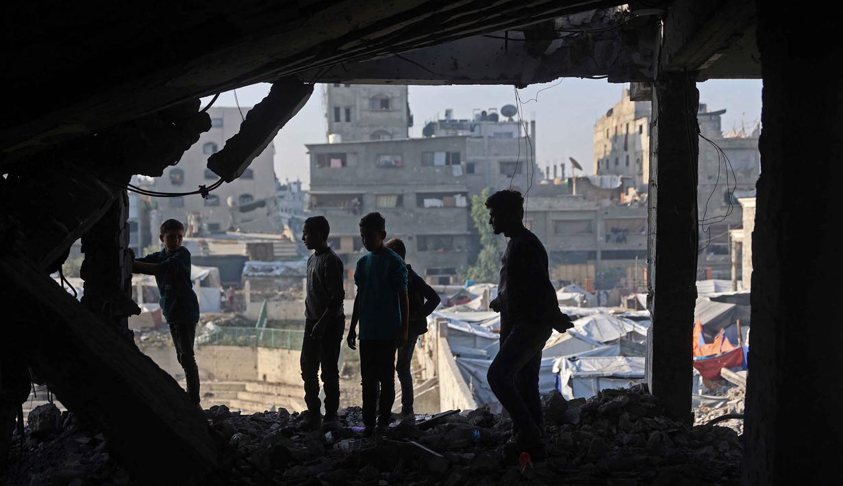 Kementerian Kesehatan Gaza mengatakan ini merupakan pelanggaran terbaru terhadap kesepakatan gencatan senjata rapuh yang berlaku sejak 10 Oktober 2025. Tampak dalam foto, warga Palestina memeriksa puing-puing bangunan yang rusak milik Kementerian Wakaf Agama, yang digunakan sebagai tempat penampungan bagi pengungsi di kawasan Zeitoun, Kota Gaza, pada Kamis 20 November 2025, sehari setelah bangunan tersebut menjadi sasaran serangan militer Israel. (Omar AL-QATTAA/AFP)