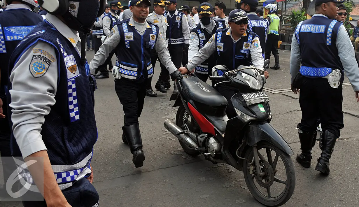Petugas Dishub, membawa sepeda motor saat razia gabungan di kawasan Tanah Abang, Jakarta, Jumat (12/6/2015). Razia gabungan Dishub, Garnisun dan Satlantas bertujuan untuk mengembalikan fungsi trotoar sebagai jalur pedestrian. (Liputan6.com/Johan Tallo)