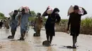 Korban banjir saat menerima bantuan Yayasan Edhi di Distrik Ghotki, Sindh Pakistan, Rabu (7/9/2022).Perkiraan menunjukkan banjir telah menyebabkan setidaknya US$ 10 miliar kerusakan di Pakistan, dan banyak orang menghadapi kekurangan makanan yang serius. Hampir setengah dari tanaman negara telah hancur. (AP Photo/Fareed Khan)