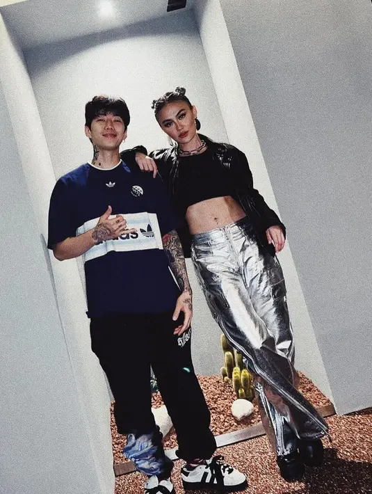 Bertemu dengan musisi Jay Park, Agnez Mo tampil dengan jaket hitam serasi dengan bra topnya dipadukan celana silver ala Y2K. [@agnezmo]