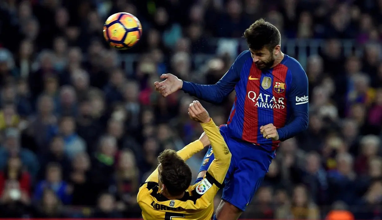 Bek Barcelona, Gerard Pique, menyundul bola ke arah gawang Malaga dalam lanjutan La Liga di Camp Nou, Barcelona, Sabtu (19/11/2016). (AFP/Lluis Gene)