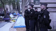 Petugas polisi berdiri di kamp darurat selama operasi pembersihan di Paris, Selasa (30/4/2023). (AP Photo/Michel Euler)
