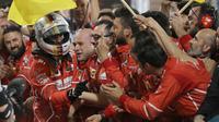 Sebastian Vettel disambut fans dan official tim usai memenangi balapan F1 GP Bahrain di Sirkuit Sakhir, Manama, Minggu (16/4/2017). (AFP/Karim Sahib)
