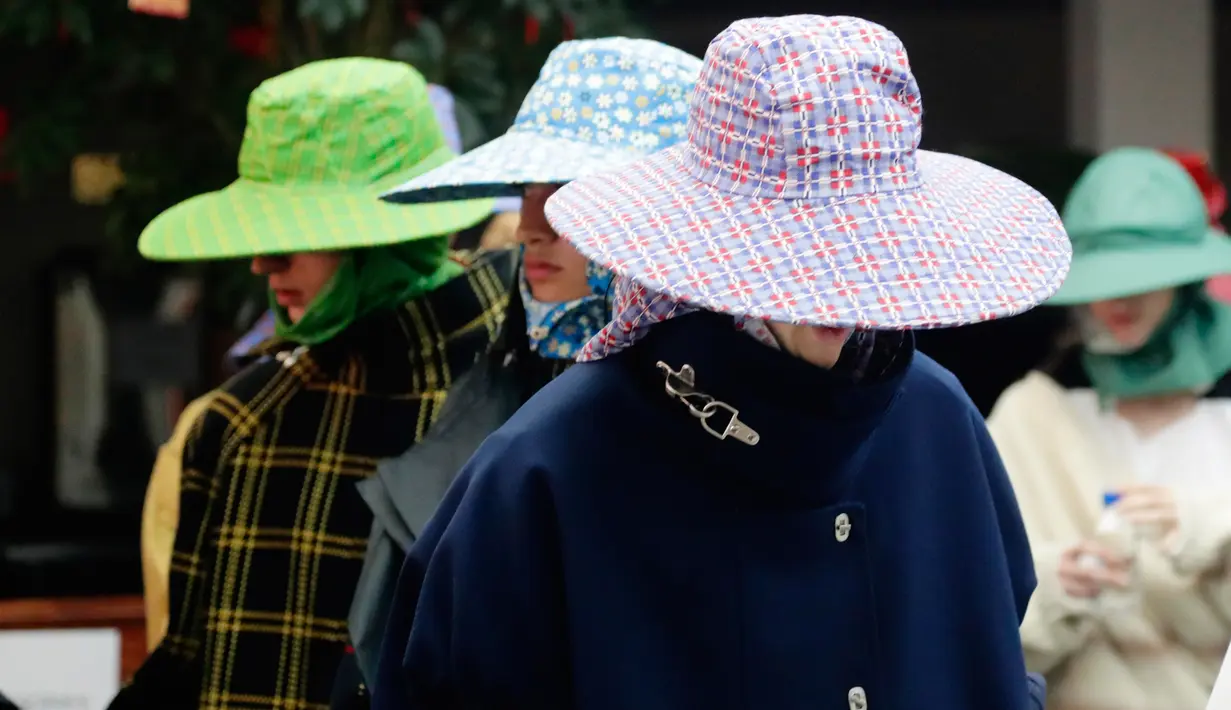 Beberapa model busana dari Raf Simons di Men’s Fashion Week, New York, Selasa (11/7). Tidak hanya topi dan payung, mantel menjadi salah satu fashion Raf dalam New York Fashion Week 2017.  (AP/Frank Franklin)