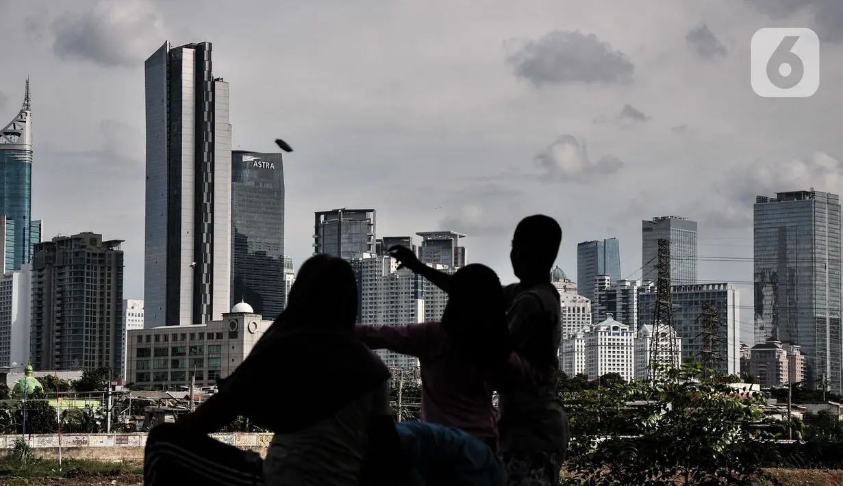 Anak-anak saat bermain dengan latar belakang gedung bertingkat di kawasan Petamburan, Jakarta, Selasa (23/11/2021). Kenaikan pendapatan negara mengindikasikan pemulihan ekonomi terus berlanjut. (merdeka.com/Iqbal S. Nugroho)
