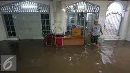 Seorang warga membersihkan banjir yang menggenangi Mesjid An Nur di kawasan Pasar Minggu, Jakarta, Selasa (4/10). Banjir yang rutin menggenangi kawasan tersebut menyebabkan aktivitas warga serta ibadah terganggu. (Liputan6.com/Immanuel Antonius)