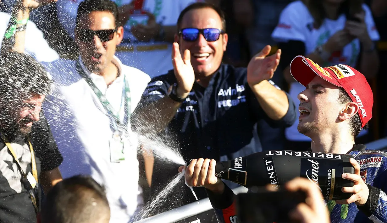 Jorge Lorenzo menyemprotkan sampanye setelah memastikan gelar juara dunia MotoGP 2015, Minggu (8/11/2015). (EPA/Kai Foersterling)