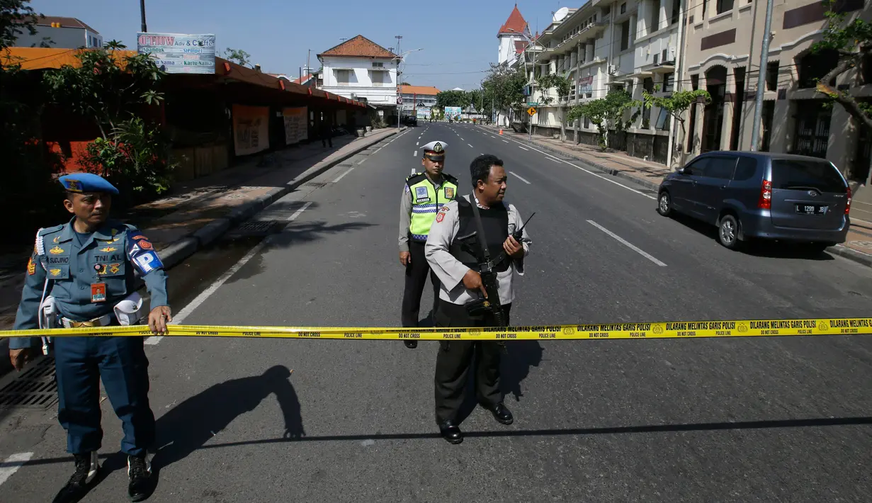 Aparat kepolisian menutup jalan menuju Polrestabes Surabaya setelah serangan bom bunuh diri di Jawa Timur, Senin (14/5). Diduga, pelaku seorang pria dan wanita yang berboncengan dengan sepeda motor dan membawa seorang anak kecil (AP/Achmad Ibrahim)