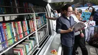 Direktur Utama PJAA Gatot Setyowaluyo membaca buku usai meluncurkan Mobil Pintar Ancol di Ancol, Jakarta, Rabu (15/6/2016). Tujuan program Mobil Pintar Ancol ini untuk meningkatkan minat baca di kalangan anak-anak. (Liputan6.com/Faizal Fanani)