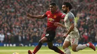 Aksi Marcus Rashford melewati Mohamed Salah pada laga lanjutan Premier League yang berlangsung di stadion Old Trafford, Manchester, Minggu (24/2). Man United bermain imbang 0-0 kontra Liverpool. (AFP/Oli Scarff)