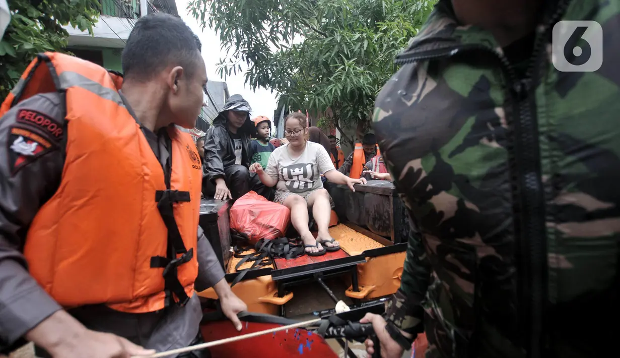 Petugas gabungan mengevakuasi warga saat banjir merendam permukiman Cipinang Melayu, Jakarta, Rabu (1/1/2020). Hujan yang terus mengguyur Jakarta sejak Selasa sore (31/12/2019) mengakibatkan banjir di sejumlah titik di wilayah Jakarta dan sekitarnya. (merdeka.com/Iqbal S Nugroho)