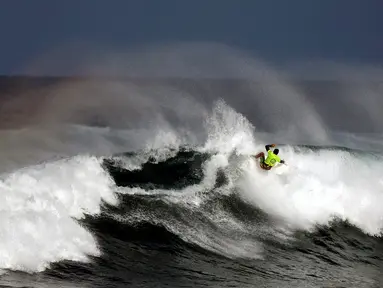 Seorang peserta beraksi menaklukan ombak selama mengikuti dalam kompetisi surfing di laut Mediterania di Ashdod, Israel, (17/11). (REUTERS/Amir Cohen)