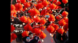 Salah satu keluarga saat berfoto di depan pohon yang dihiasi lampion dari perayaan Tahun Baru Cina di Ditan Park, Beijing (18/2/2015). Tahun Baru Imlek pada 19 Februari akan menyambut Tahun Domba. (Reuters /Kim Kyung-Hoon)