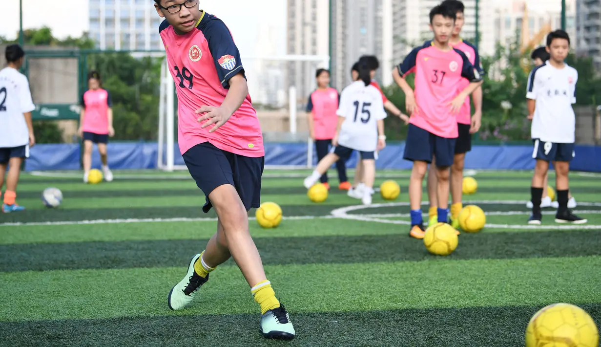 Para siswa mengikuti latihan di lapangan olah raga di atas gedung Sekolah Menengah No.10 Guangzhou, China (17/9/2020). Dikelilingi bangunan hunian yang padat, Sekolah ini memutuskan untuk "membangun secara vertikal" guna memecahkan masalah lapangan olah raga yang kurang memadai. (Xinhua/Deng Hua)