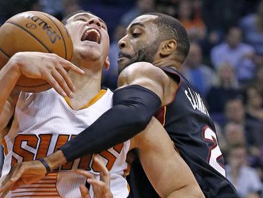 Pemain Phoenix Suns, Devin Booker (kiri) saat berebut bola dengan pemain Miami Heat, Wayne Ellington pada laga NBA basketball game, (3/1/2017) di US Airways Center, Phoenix.  Suns menang 99-90. (AP/Ross D. Franklin)