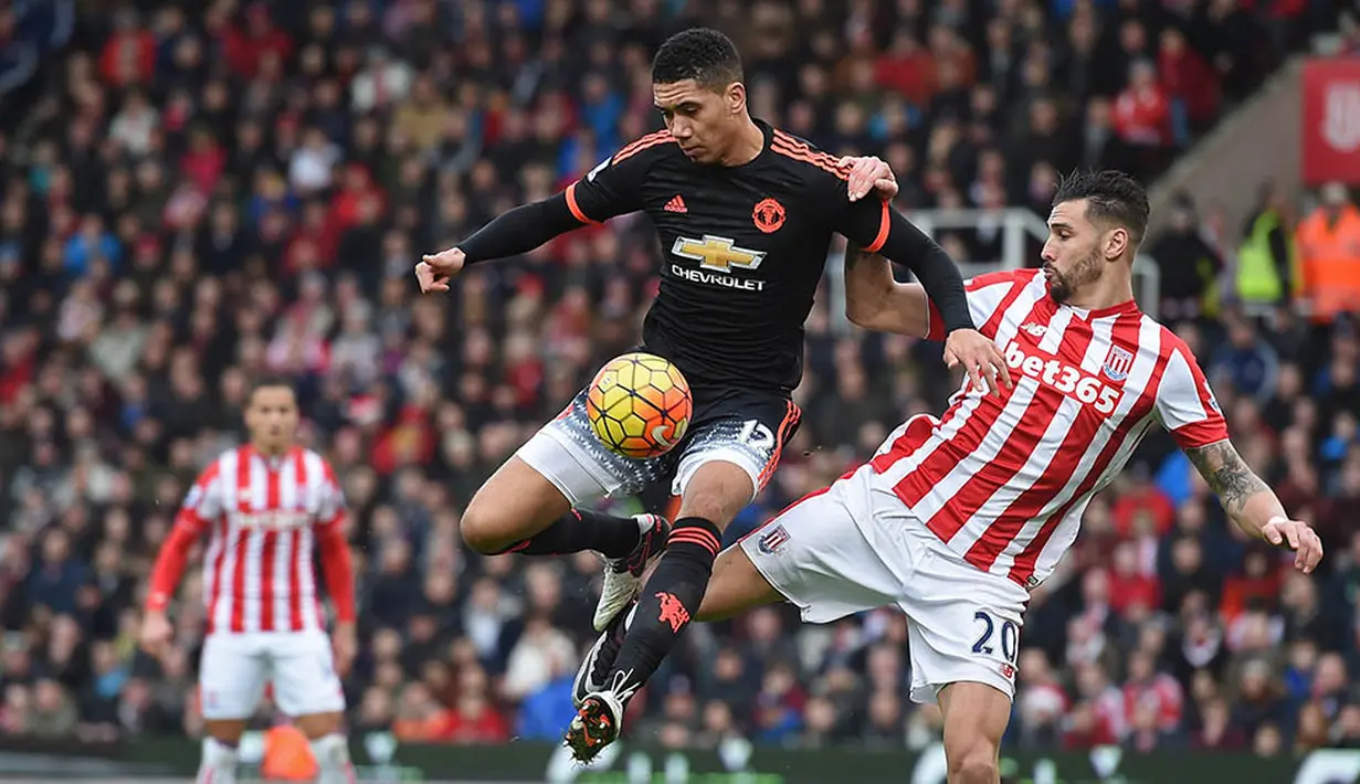 Bek Manchester United, Chris Smailling, berusaha melewati  penjagaan pemain Stoke, Geoff Cameron, pada laga Premier League. MU kalah 0-2. (AFP/Paul Ellis)