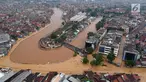 Pemandangan aerial suasana luapan sungai Ciliwung yang menggenangi Jalan Jatinegara Barat, Jakarta Timur, Selasa (6/2). Genangan tersebut membuat lalu lintas Jalan Jatinegara Barat terputus. (Liputan6.com/Arya Manggala)