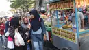 Warga berjalan di depan pedagang kaki lima yang berdagang di sebagian ruas Jalan Lada samping Kawasan Wisata Museum Fatahillah, Jakarta, Selasa (11/6/2019). Kondisi ini menyulitkan wisatawan pejalan kaki dan membuat arus lalu lintas di Jalan Lada menjadi semrawut. (Liputan6.com/Helmi Fithriansyah)