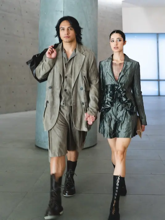 Di sisi lain, Ameera tampil sophisticated dalam blazer-dress warna olive metalik dengan tekstur crinkled yang khas. Detail ruffle dramatis di bagian depan gaun memberi dimensi sekaligus statement yang feminin. Inner sheer berwarna senada memperkuat kesan sensual namun tetap elegan.   [@littlemisskhan].