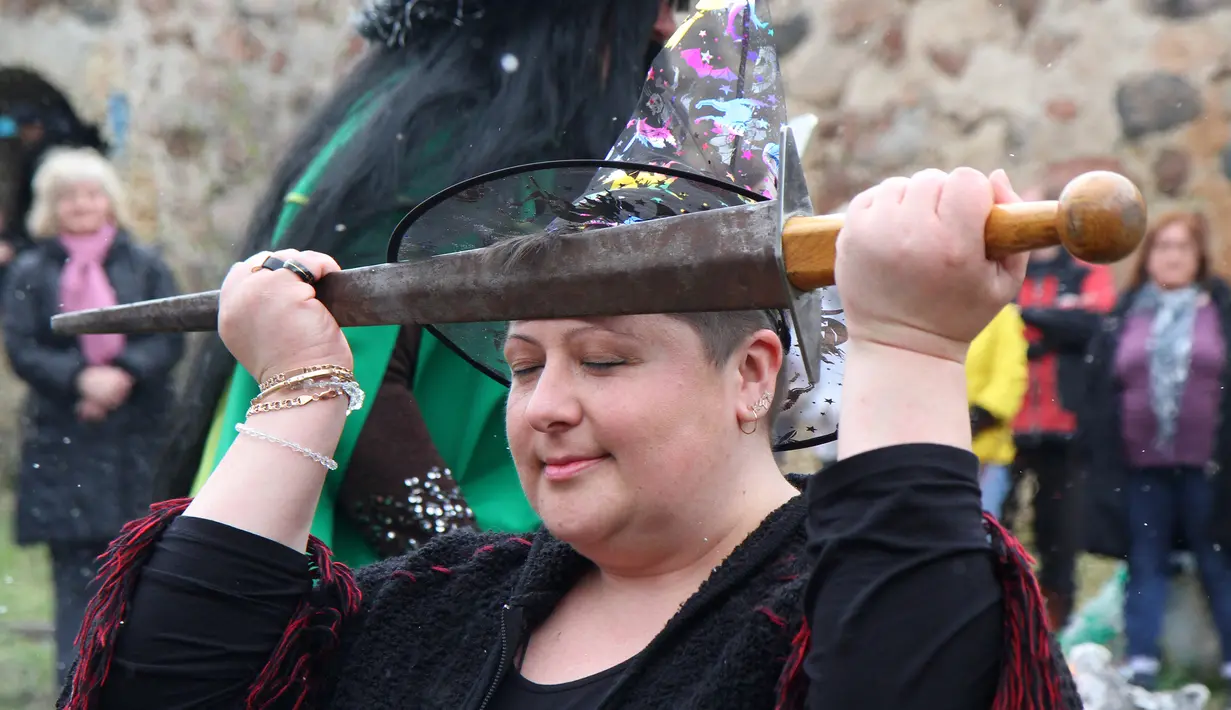 Seorang wanita melakukan ritual sihir di acara Walpurgis Night atau Witches Night di Vilnius, Lithuania, Senin (1/5). Orang-orang yang hadir mengenakan atribut layaknya para penyihir. (AFP PHOTO / Petras Malukas)