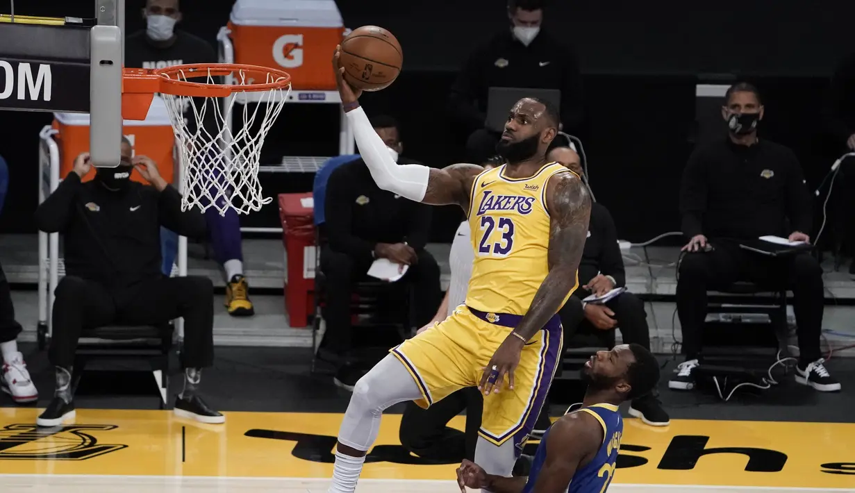 Pebasket LA Lakers LeBron James (kiri) berupaya memasukkan bola dalam pertandingan NBA melawan Golden State Warriors di Staples Center,  Los Angeles, California, Amerika Serikat, Senin (18/1/2020). (AP Photo/Jae C. Hong)