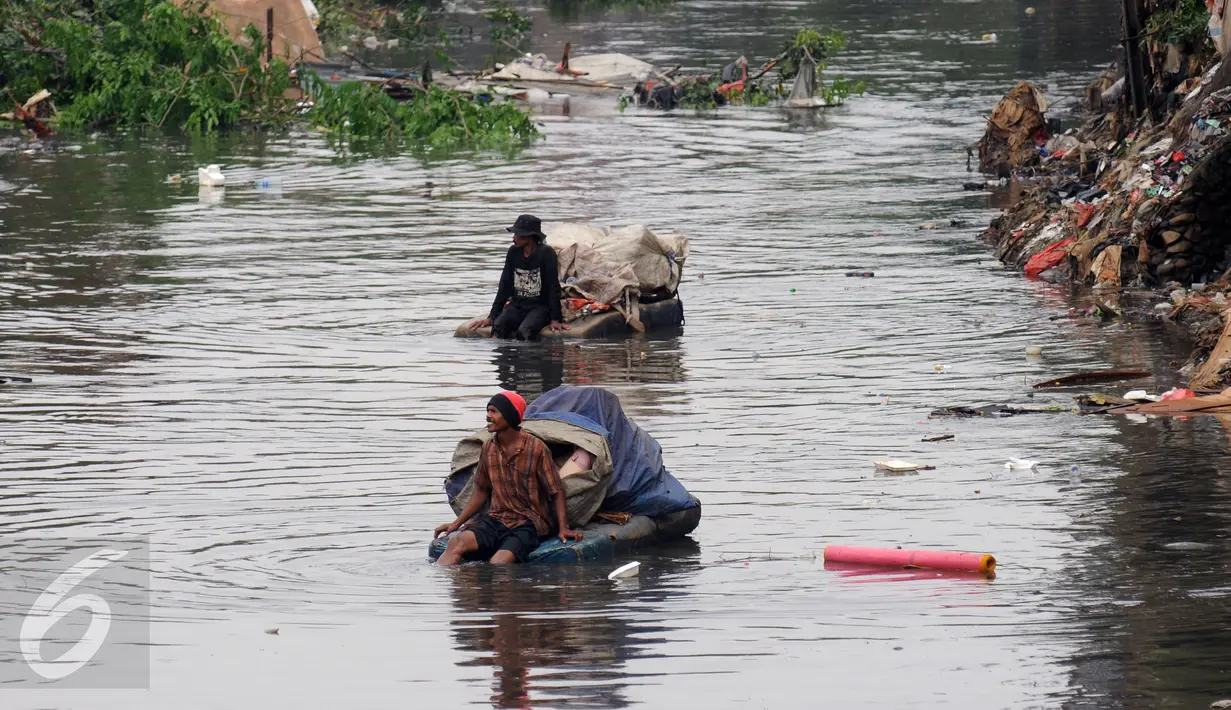 Pemulung melintasi Kali Ciliwung usai mengais sisa pembongkaran rumah warga KampungPulo, Jakarta, Jumat (21/8/2015). Penggusuran terkait rencana Pemprov DKI Jakarta yang akan melakukan normalisasi Kali Ciliwung. (Liputan6.com/Helmi Fithriansyah)