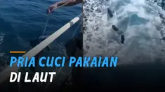 Seorang pria yang diketahui awak kapal melakukan aksi ekstrem mencuci pakaian di laut.